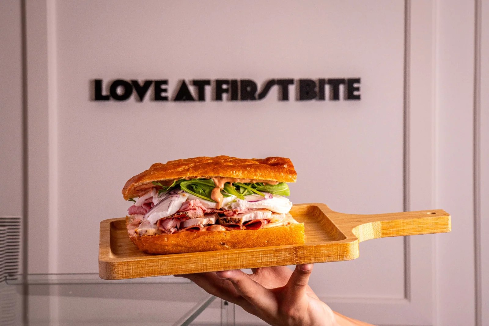 A filled focaccia sandwich on a wooden board at Smolenski’s